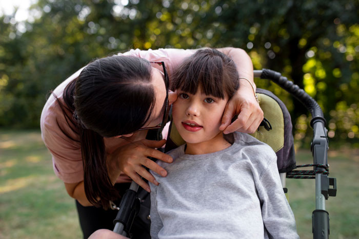 Woman showing affection to her disabled stepsister in a wheelchair, highlighting family dynamics and emotional support outdoors. Woman showing affection to her disabled stepsister in a wheelchair, highlighting family dynamics and emotional support outdoors.