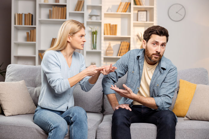 Couple having a tense discussion on sofa, illustrating challenges in marriage, kids, fertility, and relationship issues. Couple having a tense discussion on sofa, illustrating challenges in marriage, kids, fertility, and relationship issues.