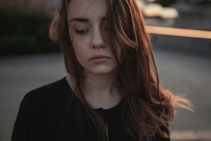 Sad young woman with long brown hair, reflecting on accusations of cheating related to daughter's dark skin and DNA test. Sad young woman with long brown hair, reflecting on accusations of cheating related to daughter's dark skin and DNA test.