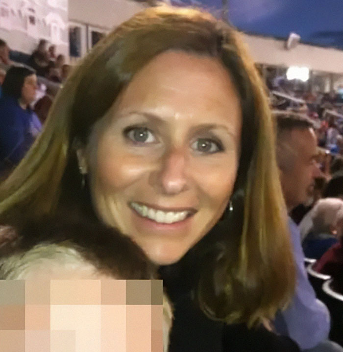 Wife of CEO accused of cheating at Coldplay concert smiling in a crowded stadium setting. Wife of CEO accused of cheating at Coldplay concert smiling in a crowded stadium setting.