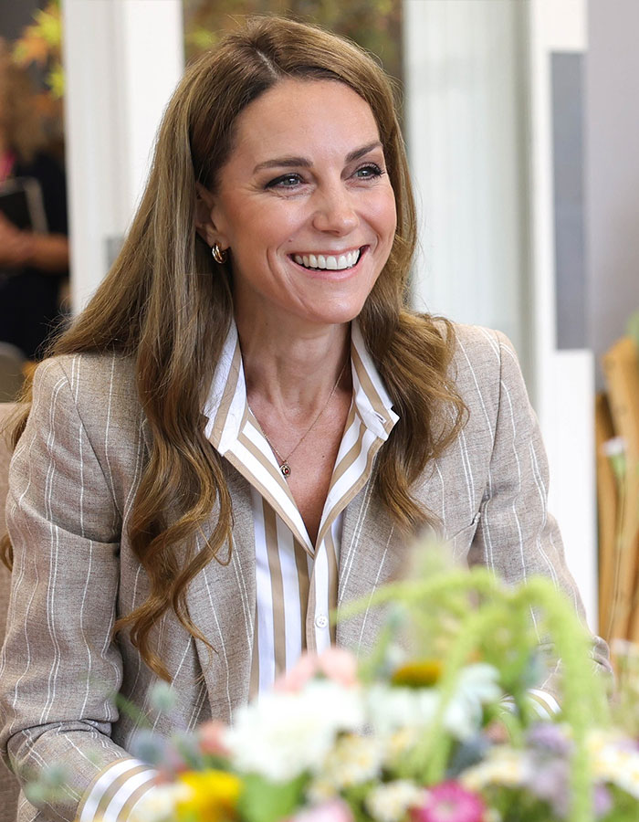 Kate Middleton’s ex-assistant smiling during a public engagement, wearing a striped shirt and light blazer. Kate Middleton’s ex-assistant smiling during a public engagement, wearing a striped shirt and light blazer.
