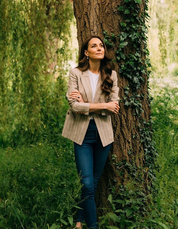 Kate Middleton’s ex-assistant standing by tree in casual blazer and jeans, looking thoughtful in a green outdoor setting. Kate Middleton’s ex-assistant standing by tree in casual blazer and jeans, looking thoughtful in a green outdoor setting.