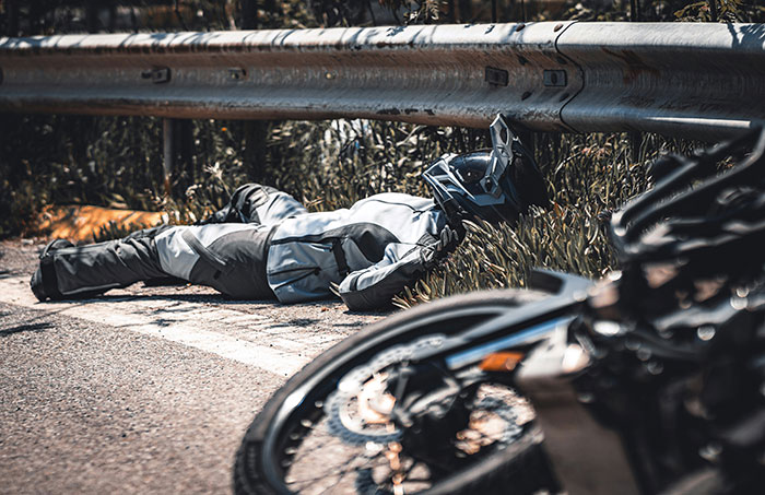 Motorcyclist lying injured by roadside after crash, illustrating tragic event in wife affair partner story. Motorcyclist lying injured by roadside after crash, illustrating tragic event in wife affair partner story.