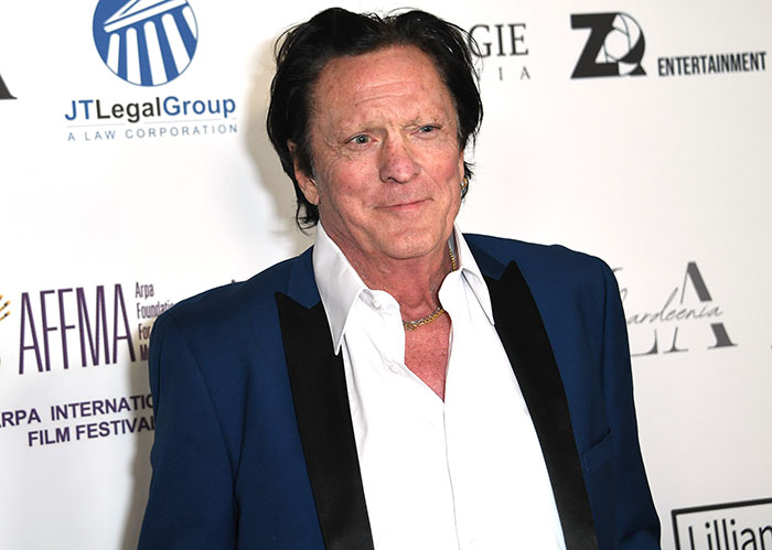 Actor Michael Madsen attends a film festival event, dressed in a blue suit jacket and white shirt, smiling for cameras. Actor Michael Madsen attends a film festival event, dressed in a blue suit jacket and white shirt, smiling for cameras.