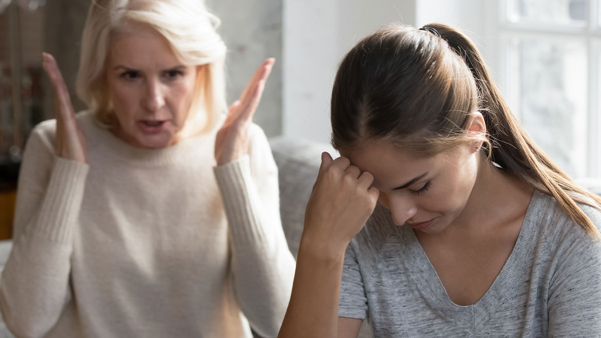 Mother angrily gesturing while daughter looks upset, depicting gaslighting after embezzlement of inheritance conflict.