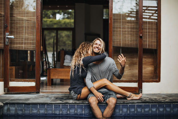 Couple enjoying a stress-free trip by the pool before their wedding, sharing a joyful and relaxed moment together. Couple enjoying a stress-free trip by the pool before their wedding, sharing a joyful and relaxed moment together.