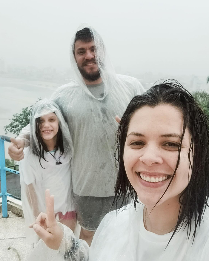 Family wearing rain ponchos smiling outdoors, highlighting the momfluencer making 9YO autistic daughter sleep on balcony. Family wearing rain ponchos smiling outdoors, highlighting the momfluencer making 9YO autistic daughter sleep on balcony.