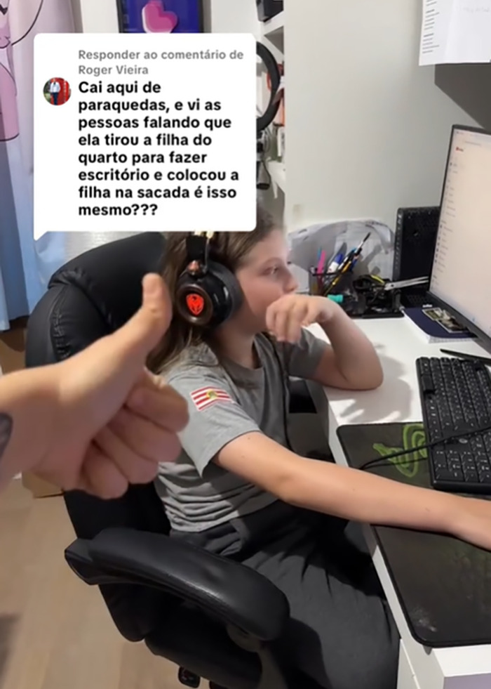 Child wearing headphones using a computer in an office setup while a hand shows thumbs up in the foreground. Child wearing headphones using a computer in an office setup while a hand shows thumbs up in the foreground.