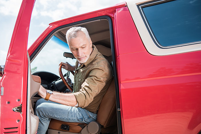 Man sitting in red truck with door open, blocking driveway and causing neighbor conflict over vehicle parking. Man sitting in red truck with door open, blocking driveway and causing neighbor conflict over vehicle parking.