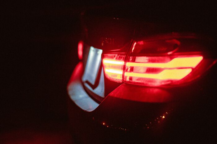 Rear view of a car tail light glowing red at night, illustrating the concept of truly outrageous student names.