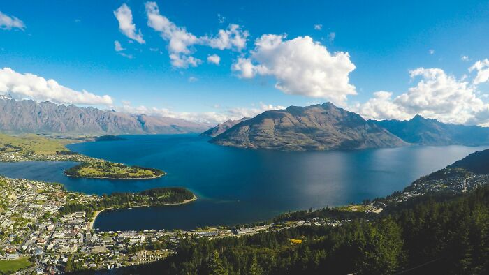 Aerial view of a smart country’s natural landscape with mountains, a lake, and a city shaping the future of the world.