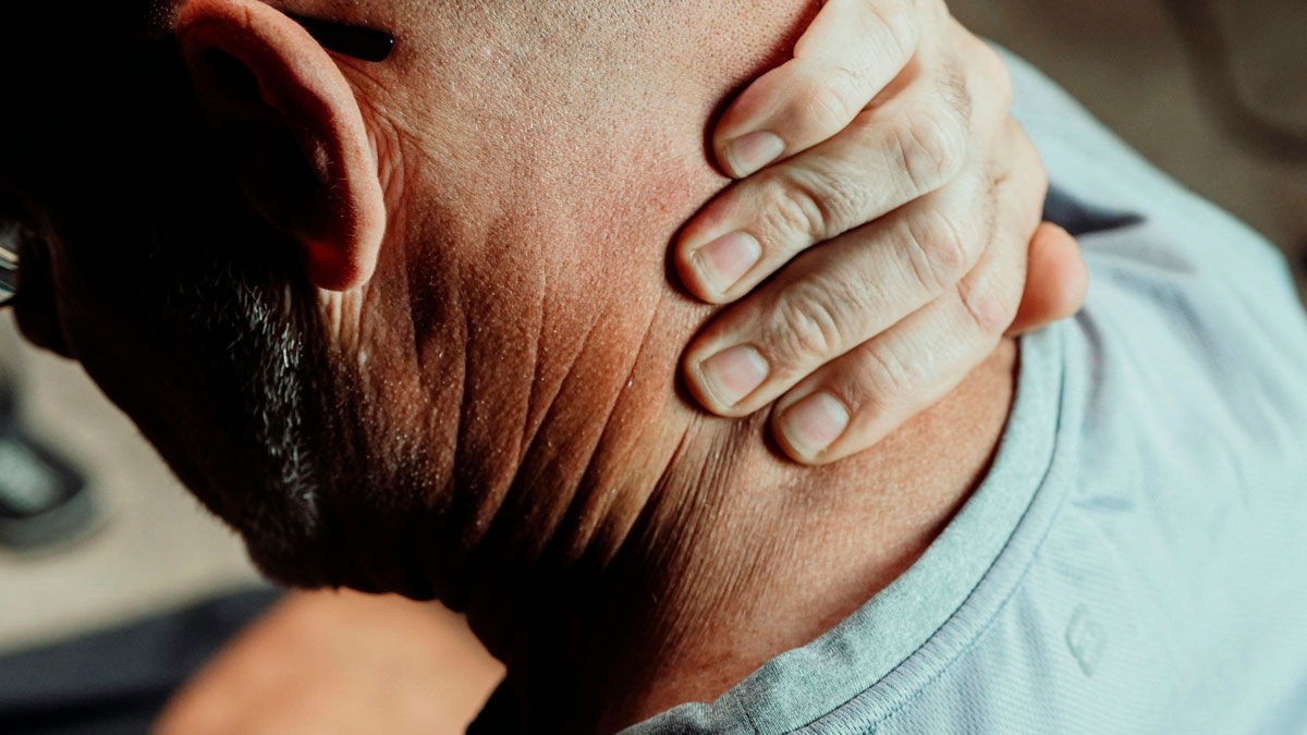 Close-up of an older man holding his neck, illustrating life after 40 and the new level of chaos it brings.