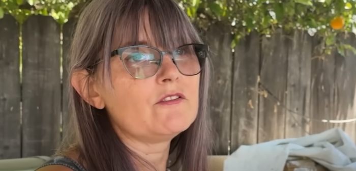 Woman wearing glasses speaking outdoors with a wooden fence in the background about mistaken Amazon package deliveries.