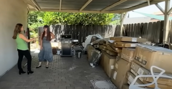 Two women talking near a large pile of Amazon packages mistakenly delivered to a woman's home for a year. Two women talking near a large pile of Amazon packages mistakenly delivered to a woman's home for a year.