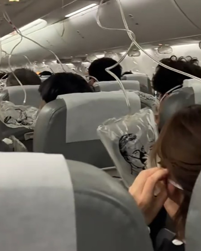 Passengers wearing oxygen masks inside Japan Airlines flight cabin during sudden 26,000 feet mid-air plunge emergency. Passengers wearing oxygen masks inside Japan Airlines flight cabin during sudden 26,000 feet mid-air plunge emergency.