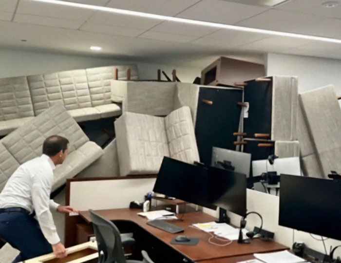 Man arranging office furniture amid a chaotic space, symbolizing the NYPD cop fatally shot protecting others. Man arranging office furniture amid a chaotic space, symbolizing the NYPD cop fatally shot protecting others.