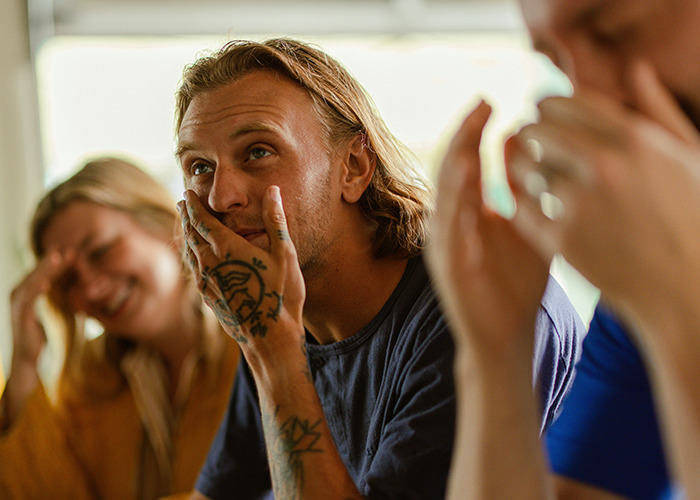 Three people reacting with mixed emotions during a conversation about savage insults in a casual setting.