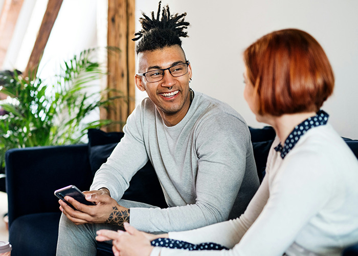 Two people having a friendly conversation indoors, highlighting social interaction and sharing savage insults discussions.