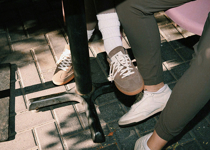 Two people wearing casual sneakers sitting at a table, highlighting relaxed moments with savage insults theme.