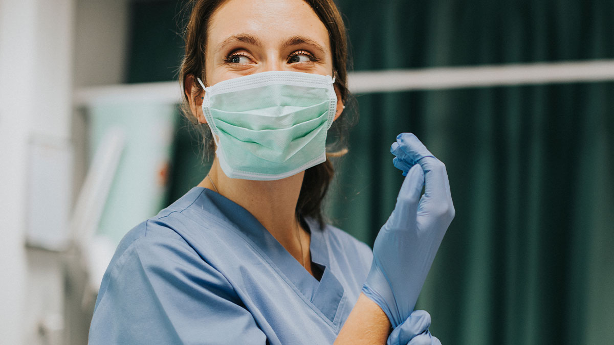 Female healthcare worker wearing mask and gloves in hospital, highlighting common terrifying and horrible mistakes made in hospitals.