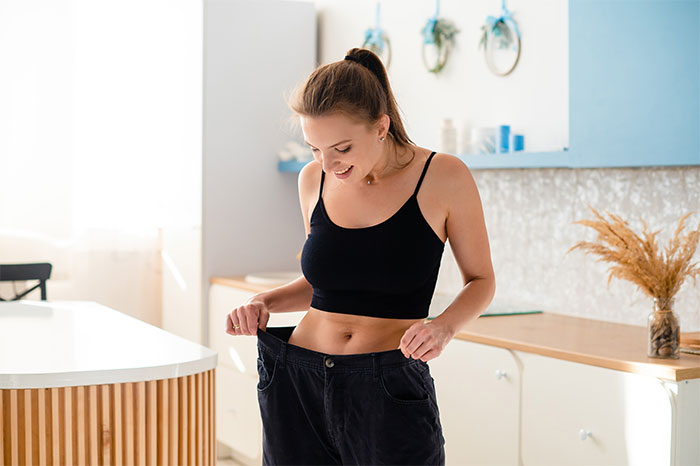 Young woman in a black top showing loose pants, illustrating the impact of loved ones taking Ozempic on weight changes. Young woman in a black top showing loose pants, illustrating the impact of loved ones taking Ozempic on weight changes.