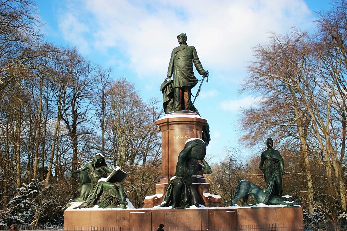 Bronze statue in a park surrounded by trees under a blue sky, illustrating outrageous student names revealed by a teacher.