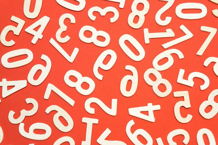 Scattered white numbers on an orange background representing general knowledge questions with numbers to type answers. Scattered white numbers on an orange background representing general knowledge questions with numbers to type answers.
