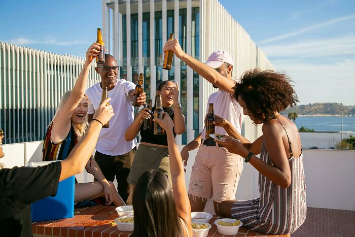 Group of friends enjoying drinks together outdoors, illustrating social signs netizens say reveal a couple’s days are numbered.