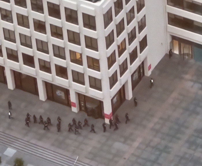Group of NYPD officers walking outside a large urban building, related to NYPD cop fatally shot while protecting others. Group of NYPD officers walking outside a large urban building, related to NYPD cop fatally shot while protecting others.