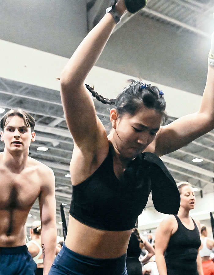 Young woman and man in workout clothes exercising in a gym, illustrating Gen Z influencer Pilates controversy. Young woman and man in workout clothes exercising in a gym, illustrating Gen Z influencer Pilates controversy.