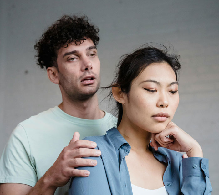Young couple with guy’s family tension as fiancé looks upset, highlighting language barrier and shocked family response. Young couple with guy’s family tension as fiancé looks upset, highlighting language barrier and shocked family response.