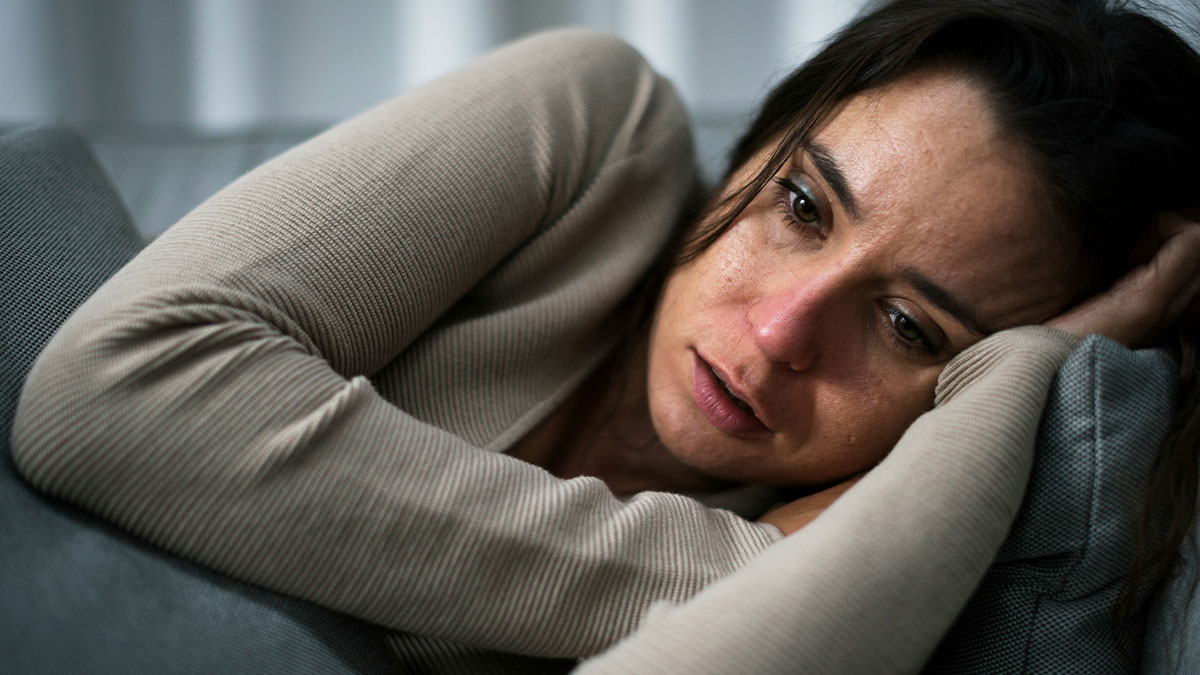 Woman lying down looking upset and emotional after a public proposal at wedding caused embarrassment and tears.