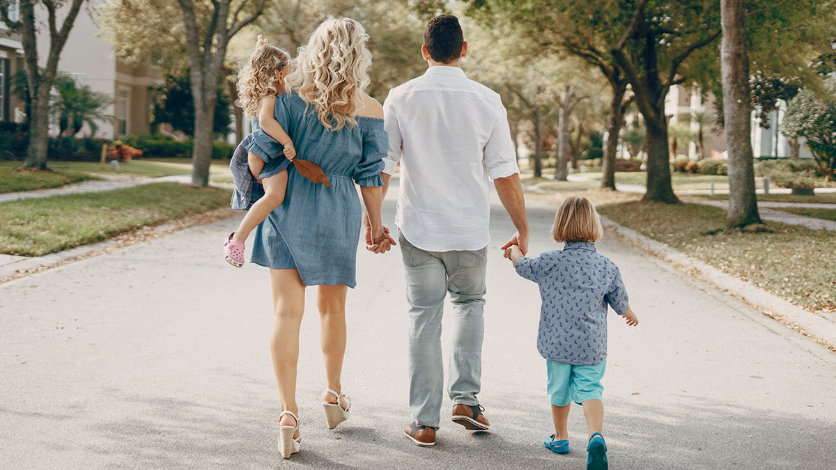 Family walking together on a suburban street, illustrating anonymous confessions that could ruin peopleu2019s lives if revealed.