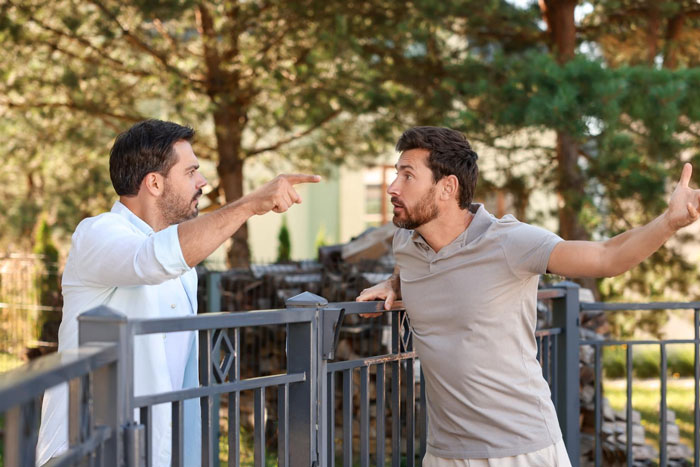 Two men arguing by a fence, illustrating a guy confronting reality about public road parking space in front of his house. Two men arguing by a fence, illustrating a guy confronting reality about public road parking space in front of his house.