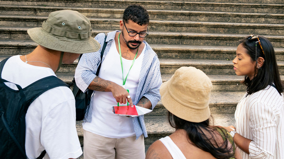 Tour company guide explaining details to tourists on steps, representing family tour and childfree couple controversy.