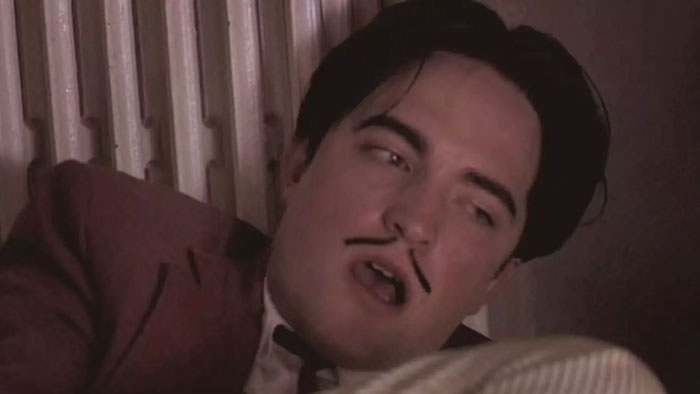 Robert Pattinson in a close-up shot with a drawn-on mustache, recalling a challenging Twilight intimate scene. Robert Pattinson in a close-up shot with a drawn-on mustache, recalling a challenging Twilight intimate scene.