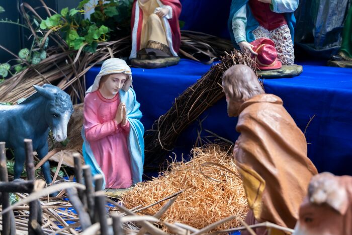 Nativity scene figures depicting Jesus and others arranged with straw, representing religious myths and Bible stories.