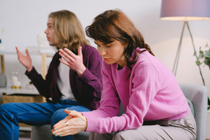 Woman in pink sweater upset while boyfriend’s roommate watches Jurassic Park in living room dispute about dinosaurs. Woman in pink sweater upset while boyfriend’s roommate watches Jurassic Park in living room dispute about dinosaurs.