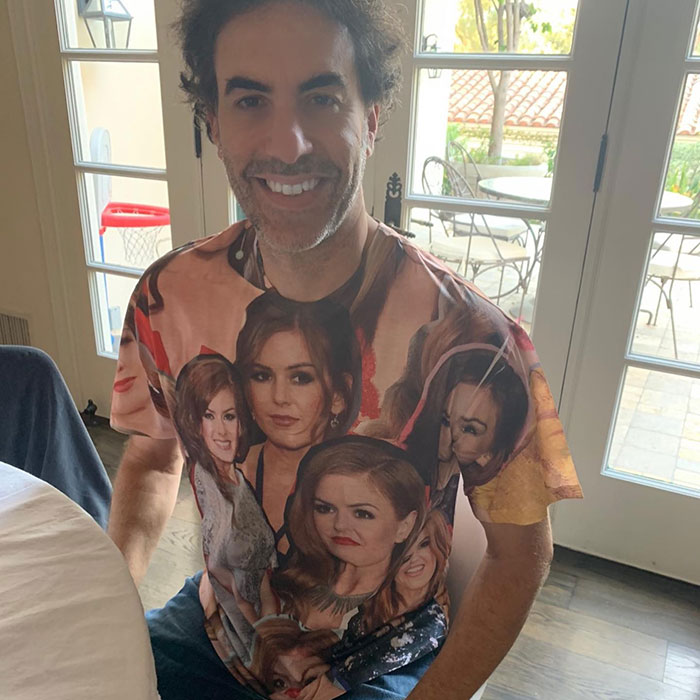 Man smiling indoors wearing a colorful shirt covered with multiple images of Isla Fisher, related to marriage news. Man smiling indoors wearing a colorful shirt covered with multiple images of Isla Fisher, related to marriage news.