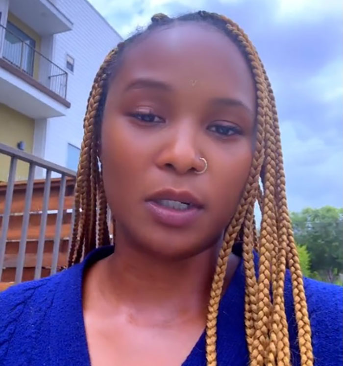 Young woman with long braids speaking outdoors about official causing outrage by calling flood-stricken Camp Mystic whites-only. Young woman with long braids speaking outdoors about official causing outrage by calling flood-stricken Camp Mystic whites-only.