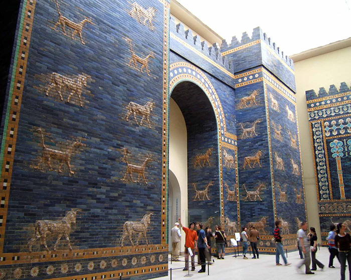 Ancient blue and gold brick wall with animal motifs in a museum, highlighting mysterious 3,000-year-old text on women's roles.