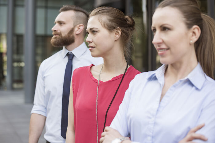 Three confident professionals standing outdoors, reflecting on sentences that changed people’s lives and inspired growth.