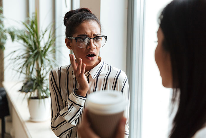 Young woman in glasses expressing shock while talking to a friend about fiancé’s female friend demands and wedding roles. Young woman in glasses expressing shock while talking to a friend about fiancé’s female friend demands and wedding roles.