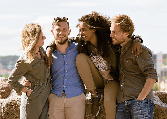 Group of friends smiling and enjoying outdoors, illustrating signs you grew up sheltered through their close bond and interaction