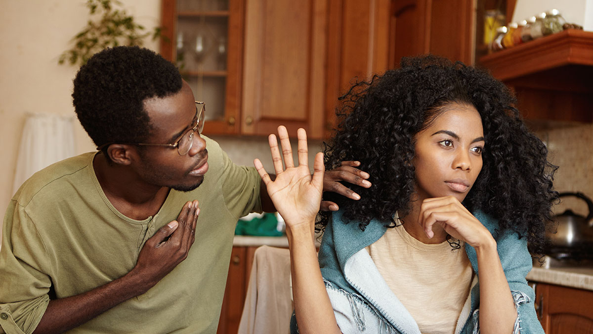 Woman avoiding man in kitchen showing reasons why single women avoid men like the plague in relationships.