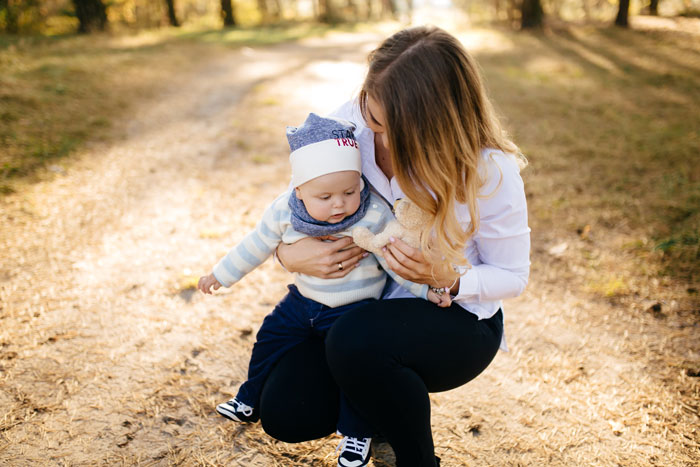 Woman holding baby outdoors in autumn, symbolizing lady getting revenge on sister's bad ex through baby naming. Woman holding baby outdoors in autumn, symbolizing lady getting revenge on sister's bad ex through baby naming.