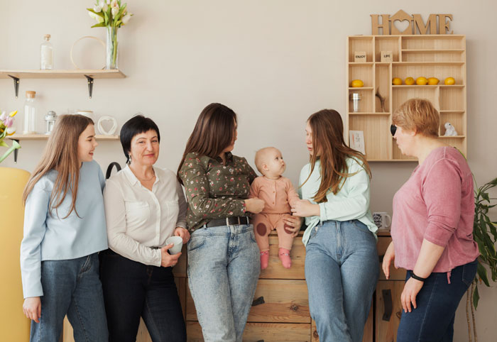 Group of women with a baby, capturing emotions around baby-mad woman who can’t conceive and family tensions. Group of women with a baby, capturing emotions around baby-mad woman who can’t conceive and family tensions.