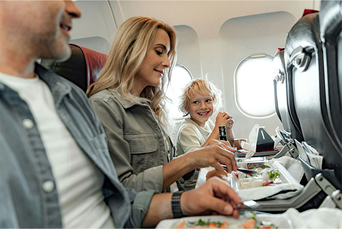 Woman sneakily swaps airplane seats to avoid babysitting little sister during family trip paid by dad, smiling while eating. Woman sneakily swaps airplane seats to avoid babysitting little sister during family trip paid by dad, smiling while eating.