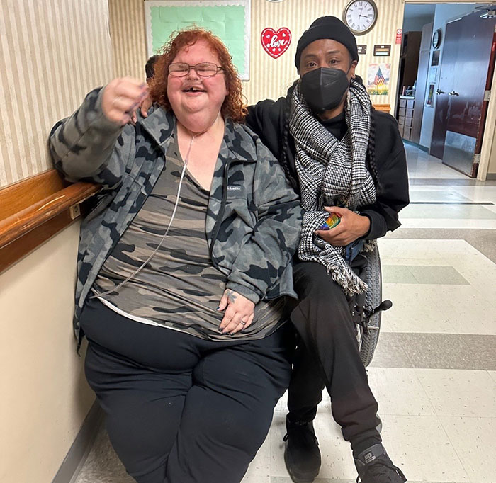 Tammy Slaton from 1000-Lb. Sisters sitting next to a friend, both smiling in a hallway setting after surgery. Tammy Slaton from 1000-Lb. Sisters sitting next to a friend, both smiling in a hallway setting after surgery.