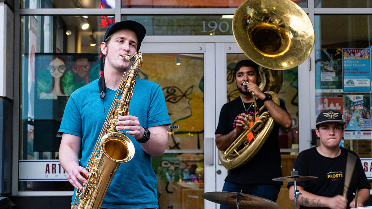 Three young musicians playing saxophone, sousaphone, and drums, illustrating diverse student names shared by a teacher.